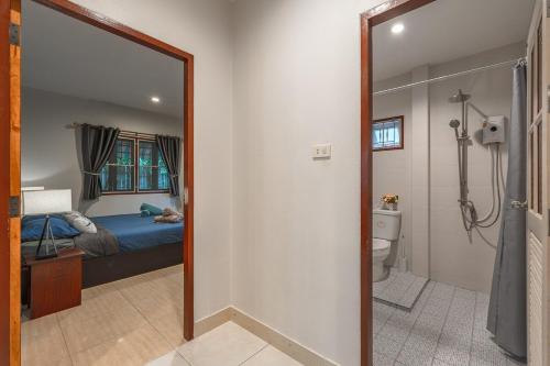 a bathroom with a bed and a shower and a mirror at Coastline Pearl Holiday Home, Bangtao Beach in Ban Thalat Choeng Thale