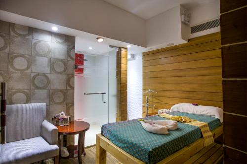 a bedroom with a shower and a bed and a chair at Bengal Blueberry in Dhaka