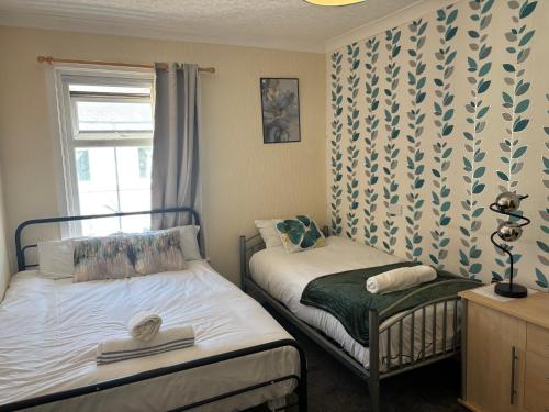 a small bedroom with two beds and a window at Affordable Golden Mile Hotel In Blackpool Close To The Beach And Blackpool City Centre With Free Street Parking Subject To Availabilty in Blackpool