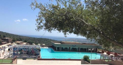 a building with a swimming pool with a view of the ocean at Residenza Verde Mare Cugnana village in Cugnana Verde