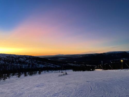 a ski slope with the sun setting in the background at Nybyggd stuga i Orrliden in Sälen
