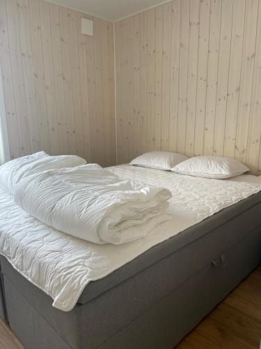 an unmade bed with white sheets and pillows on it at Nybyggd stuga i Orrliden in Sälen