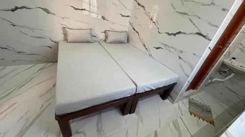 a platform bed in a bathroom with marble walls at RR Residency in Vishāram