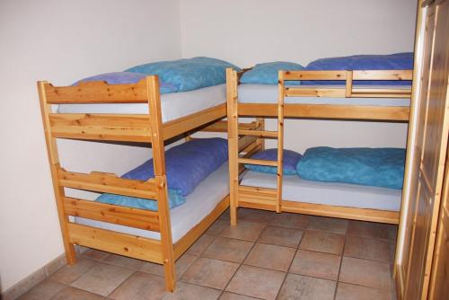 a room with three bunk beds with blue sheets at Casa Migiur 3,5 Zimmer-Apartment in Laax