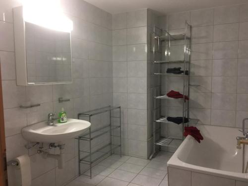 a bathroom with a sink and a shower and a tub at Casa Migiur 3,5 Zimmer-Apartment in Laax