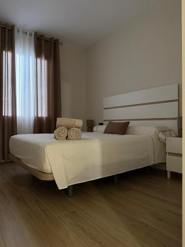a bedroom with a large white bed with two pillows at El GABINETE in Argamasilla de Alba