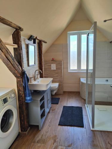 a bathroom with a sink and a washing machine at Zentrale Altbau FEWO in Flensburg