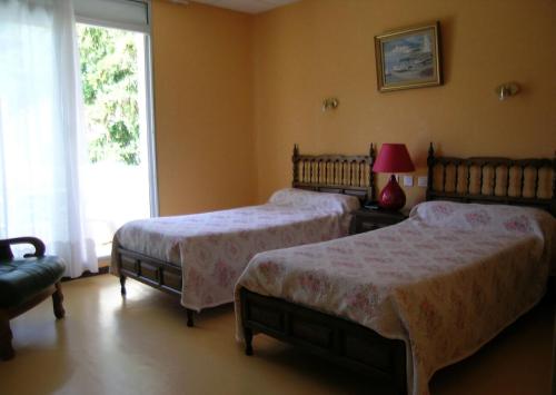 a bedroom with two beds and a window at Hôtel LA PERGOLA in Amélie-les-Bains-Palalda