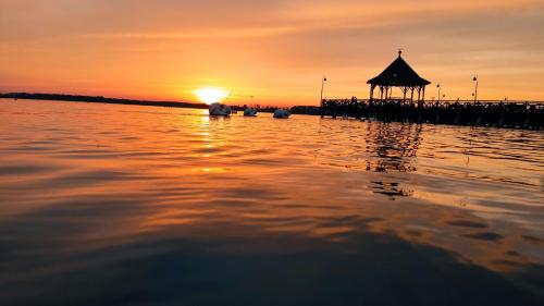 un molo con gazebo sull'acqua al tramonto di SWKD - Kameralne Apartamenty a Ostróda