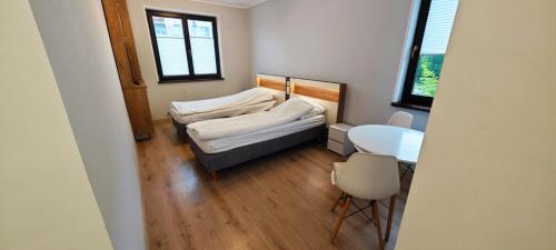 una piccola stanza con due letti e un tavolo di SWKD - Kameralne Apartamenty a Ostróda