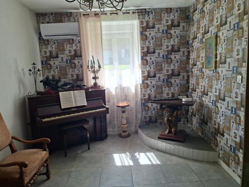 a room with a piano in a room with wallpaper at Maison spacieuse et calme in Bayonville