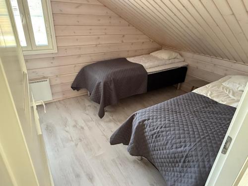 a bedroom with two beds in a attic at Villa Hile - 8 hengen mökki, rauhallinen sijainti Himoksen ytimessä in Jämsä