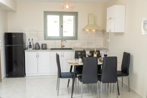 a kitchen with a table with chairs and a black refrigerator at THISEFS luxury apartments Kefalonia in Antipata