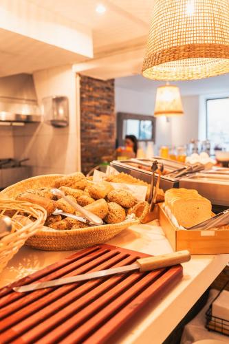 a counter with a bowl of bread and utensils at Hotel La Milagrosa in Alicante