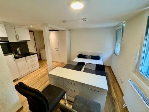 a small room with a bed and a desk and chairs at Wohnung Seewen in Schwyz