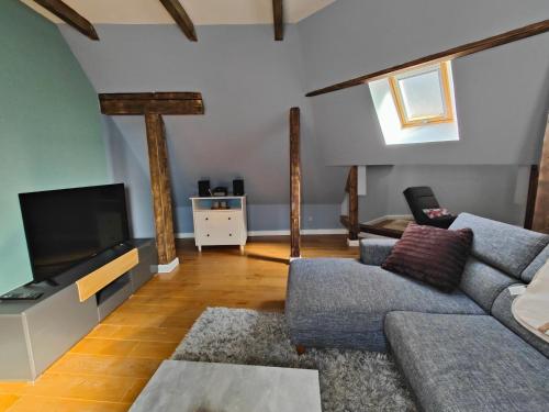 a living room with a couch and a flat screen tv at Zentrale Altbau FEWO in Flensburg