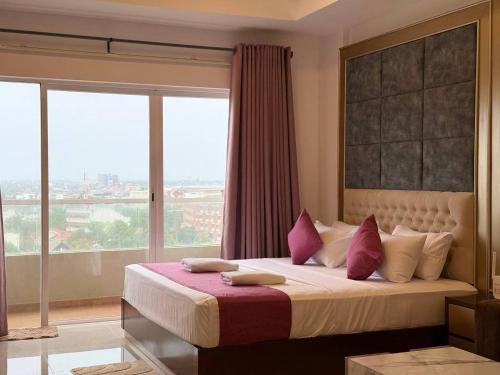 a bedroom with a large bed with a large window at High Tides End Ceylon Negombo in Negombo