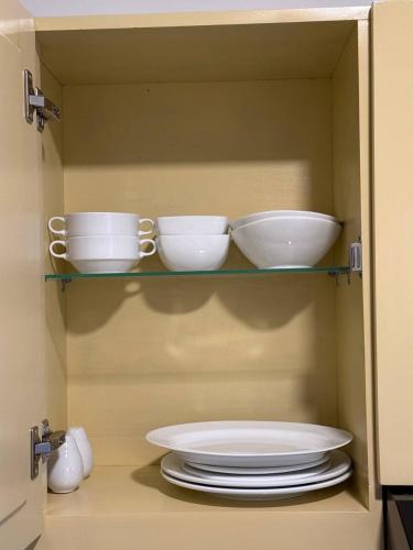 a cabinet with plates and bowls on a shelf at High Tides End Ceylon Negombo in Negombo