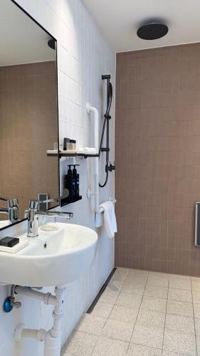 a bathroom with a sink and a mirror at Elkonin Tel Aviv - MGallery Hotel Collection in Tel Aviv