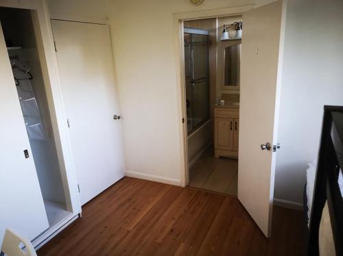 a bathroom with white walls and a wooden floor at Olive Startup House in Palo Alto