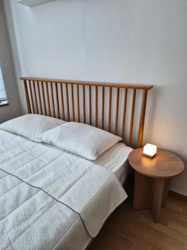 a bed with a wooden head board and a wooden table at Hongdae Home Sweet Home in Seoul