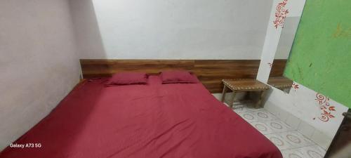 a small bedroom with a red bed in a room at Annu Bhai Sewa Sadan in Mathura