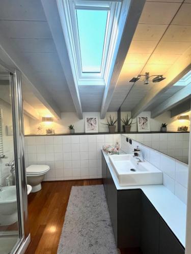 a bathroom with a sink and a toilet and a skylight at Studio21 in Monza