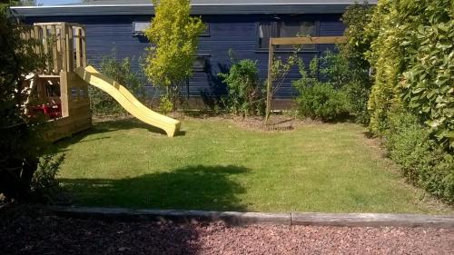 a yellow slide in the yard of a house at Vakantie Chalet Makkum in Makkum
