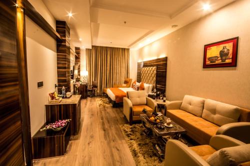 a hotel room with a couch and a bed at Regenta Central Amritsar in Amritsar