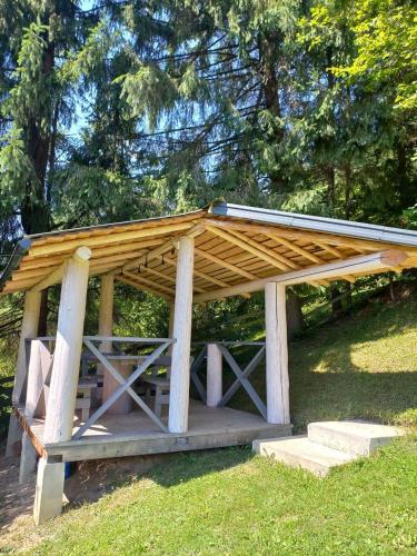 a wooden pavilion with stairs in the grass at Шепіт лісу in Lazeshchyna
