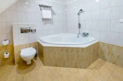 a bathroom with a bath tub and a toilet at Hotel Golden Eagle in Levice