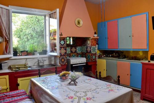 a kitchen with colorful cabinets and a table with a vase on it at Περγαμόντο in Chios