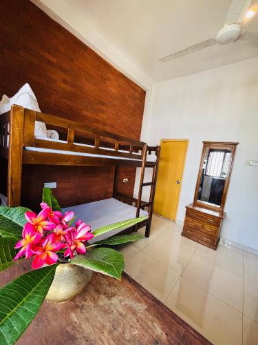 a bedroom with bunk beds and a flower in a vase at SENUKi in Galle