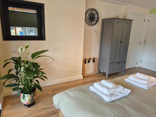 a room with two towels on a bed with a plant at Goed Verblijf in Liempde
