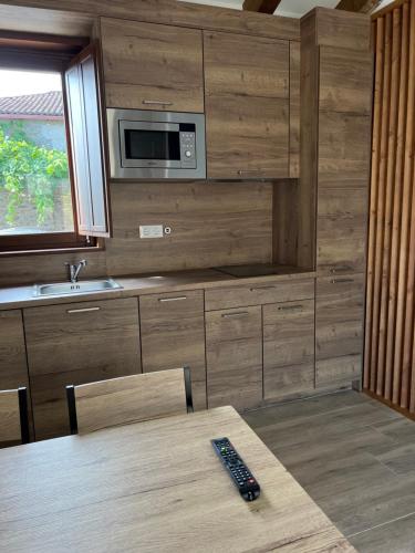 a kitchen with a table with a remote control on it at AMC Boente in Arzúa