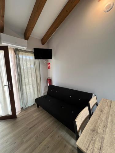 a living room with a black couch and a table at AMC Boente in Arzúa