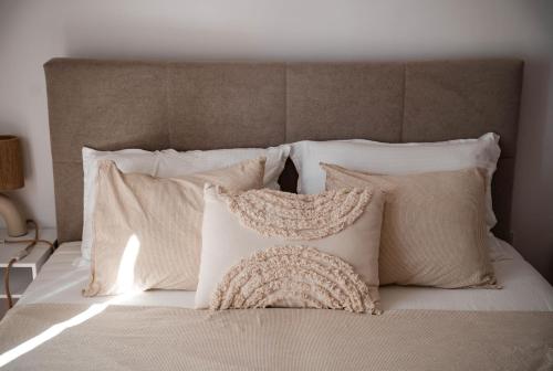 a bed with white pillows and a headboard at La casa Zamora in Totana