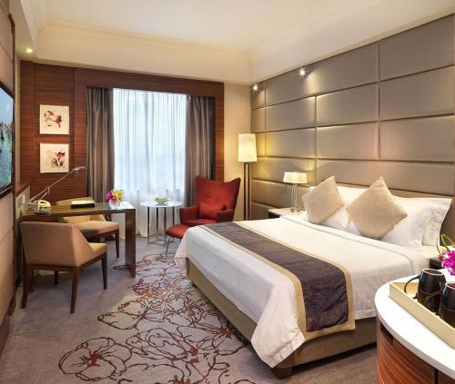 Una habitación de hotel con una cama grande y un escritorio. en Hotel Hampton Near Delhi Airport, en Nueva Delhi