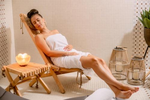 a woman sitting in a chair in a bath room at Hotel Golden Eagle in Levice
