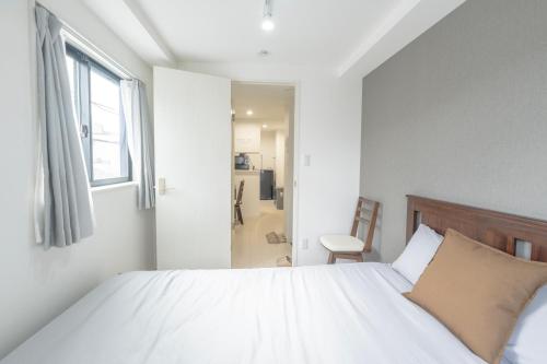 Un dormitorio blanco con una cama y una ventana. en 三ノ輪駅徒歩圏 交通便利 浅草観光 ショッピング グルメを満喫する日本堤ステイ DsL, en Tokio
