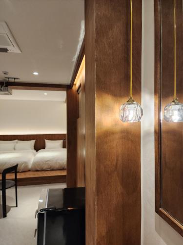 a bedroom with a bed and two lights on the wall at Gangneung All Stave Hotel in Gangneung