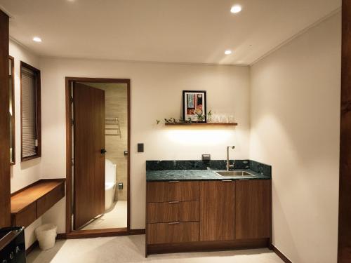a bathroom with a sink and a mirror at Gangneung All Stave Hotel in Gangneung