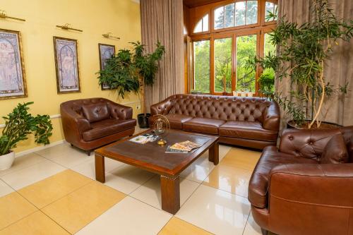 a living room with leather couches and a coffee table at Hotel Golden Eagle in Levice