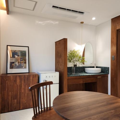 a kitchen with a wooden table and a sink at Gangneung All Stave Hotel in Gangneung