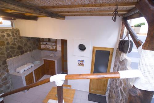 a man holding a baseball bat in a kitchen at B&B da Luca in Panarea