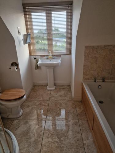 un bagno con lavandino, WC e vasca di The Mill House a Meare