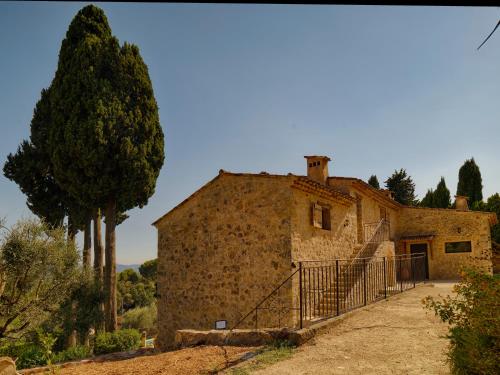 an old stone building with a gate in front of it at Mas des quatre cyprès in Spéracèdes
