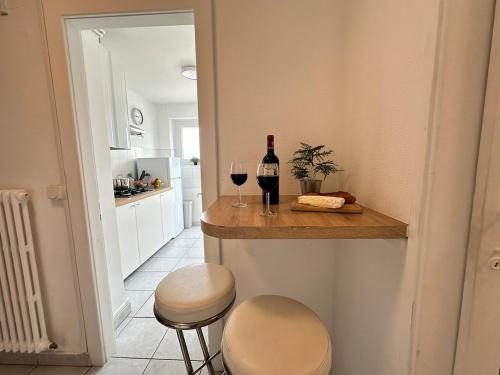 a kitchen with a bar with a bottle of wine and two stools at M Lorry Pop Art 3 chambres avec balcons proche Metz in Metz