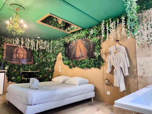 a room with a bed and plants on the wall at L'éxperience LOVE ROOM in LʼÉtrat