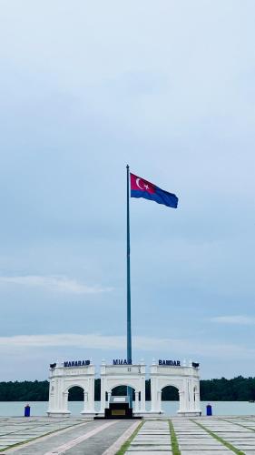 a white building with a flag on top of it at Homestay Anak Mem Senah in Muar in Gua Sai